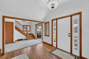 Entryway with light wood-style floors, a barrel ceiling, and hanging lights