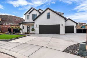 Modern farmhouse style home featuring brick siding, driveway, stucco siding, and covered porch