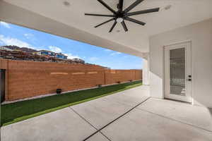 Fenced backyard with a patio and ceiling fan