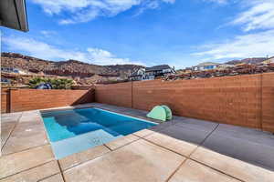 View of pool featuring a fenced backyard, a mountain view, and patio surround
