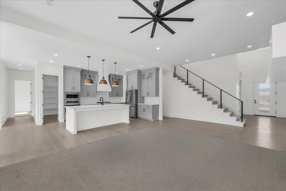 Unfurnished living room featuring ceiling fan, light wood-style flooring, and recessed lighting