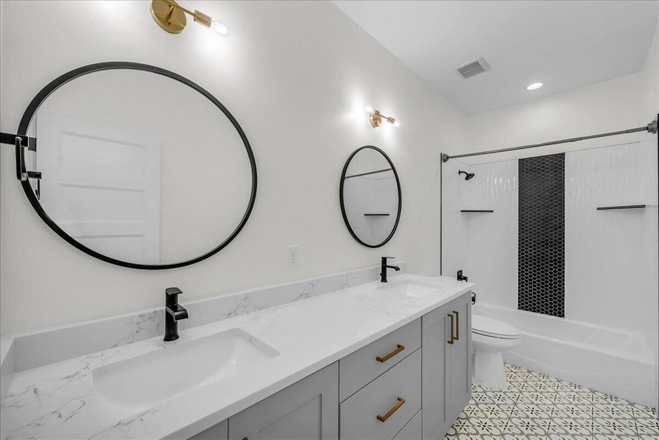 Full bath with double vanity and shower / tub combination