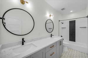 Full bath with double vanity and shower / tub combination