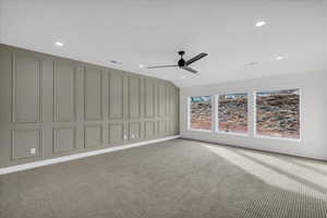 Empty room featuring a ceiling fan, light colored carpet, a decorative wall, and recessed lighting
