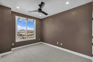 Empty room featuring a ceiling fan, light carpet, and recessed lighting