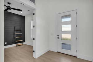 Foyer featuring healthy amount of natural light, light wood-style flooring, ceiling fan, an accent wall, and recessed lighting