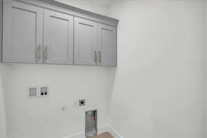 Laundry area featuring hookup for a gas dryer, washer hookup, cabinet space, hookup for an electric dryer, and light wood-style floors