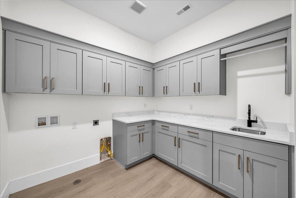 Laundry room featuring cabinet space, light wood-style flooring, washer hookup, and hookup for an electric dryer