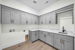 Laundry room featuring cabinet space, light wood-style flooring, washer hookup, and hookup for an electric dryer