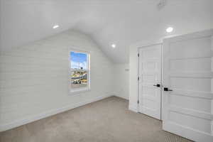 Additional living space with recessed lighting and light carpet