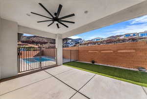 Fenced backyard with ceiling fan and a patio