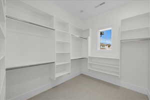 Walk in closet featuring light colored carpet