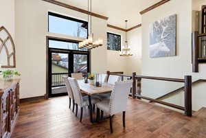 Dining space featuring crown molding, dark wood-type flooring, and hanging lights