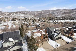 Snowy aerial view featuring a residential view and a mountain view