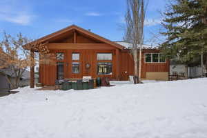 Snow covered property with a patio
