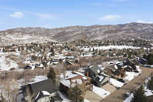 Snowy aerial view featuring a mountain view and a residential view