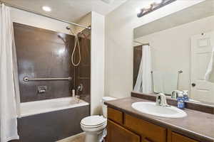 Bathroom featuring vanity, shower / tub combo with curtain, and light tile patterned floors