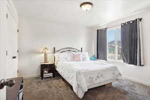 Carpeted bedroom featuring a closet and baseboards