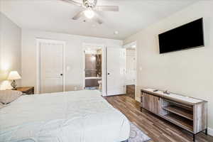 Bedroom featuring ceiling fan, dark wood finished floors, and connected bathroom