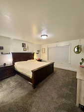 Bedroom featuring dark carpet