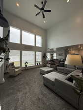 Living room with a high ceiling, carpet, a ceiling fan, and recessed lighting