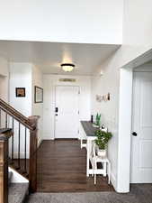Foyer entrance with stairs and dark wood-style floors