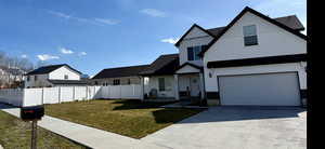 Modern farmhouse featuring covered porch, concrete driveway, an attached garage, and board and batten siding