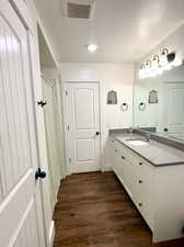 Bathroom featuring vanity, a shower with curtain, dark wood-type flooring, and recessed lighting