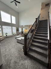 Stairway with a high ceiling, carpet flooring, ceiling fan, and recessed lighting