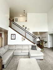 Living area with a high ceiling, carpet, and recessed lighting