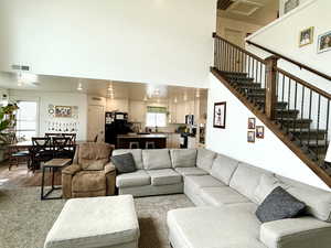 Living area with wood finished floors, recessed lighting, and a high ceiling