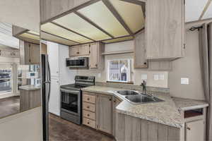 Kitchen with stainless steel appliances, light countertops, dark wood finished floors, and light wood finish cabinets