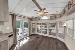 Unfurnished sunroom with beam ceiling, wood finished floors, and french doors