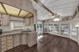 Kitchen featuring light countertops, light wood finish cabinetry, vaulted ceiling, dark wood finished floors, and ceiling fan