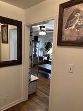 Hallway featuring dark wood finished floors and baseboards