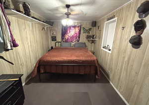 Bedroom with wooden walls and ceiling fan