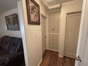 Hallway featuring dark wood-style flooring and baseboards