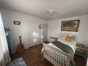 Bedroom with dark wood-style floors and a closet
