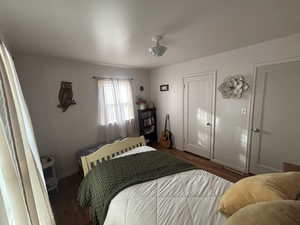 Bedroom with dark wood-type flooring and baseboards