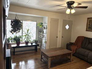Living area with dark wood-style flooring and ceiling fan