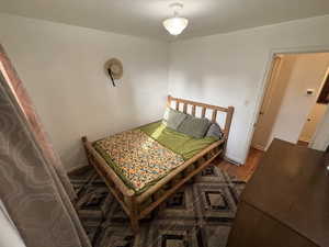 Bedroom with wood finished floors and baseboards