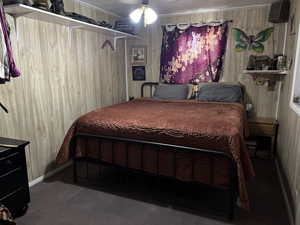 Bedroom featuring wood walls and baseboards