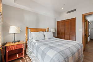 Bedroom featuring a closet, dark wood-type flooring, and recessed lighting