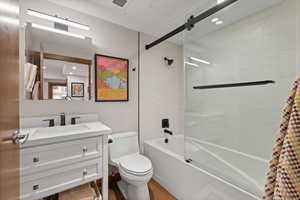 Bathroom with combined bath / shower with glass door, vanity, recessed lighting, and light wood finished floors
