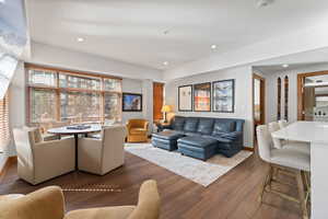 Living room with dark wood finished floors, healthy amount of natural light, and recessed lighting