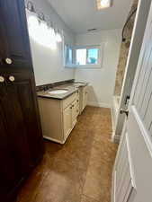 Full bath featuring double vanity and tub / shower combination