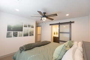 Bedroom featuring a barn door, ceiling fan, recessed lighting, connected bathroom, and carpet floors
