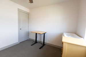 Unfurnished bedroom with ceiling fan and dark carpet