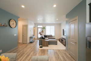 Living room featuring light wood-style flooring and recessed lighting