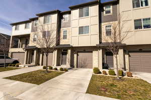 View of front of house with stone siding, concrete driveway, and a garage